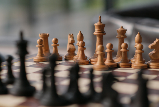 Closeup of a chess board with wooden chess pieces