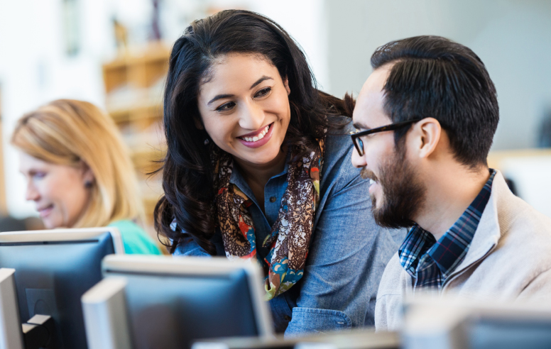 Woman and man engaging in conversation in an office setting.