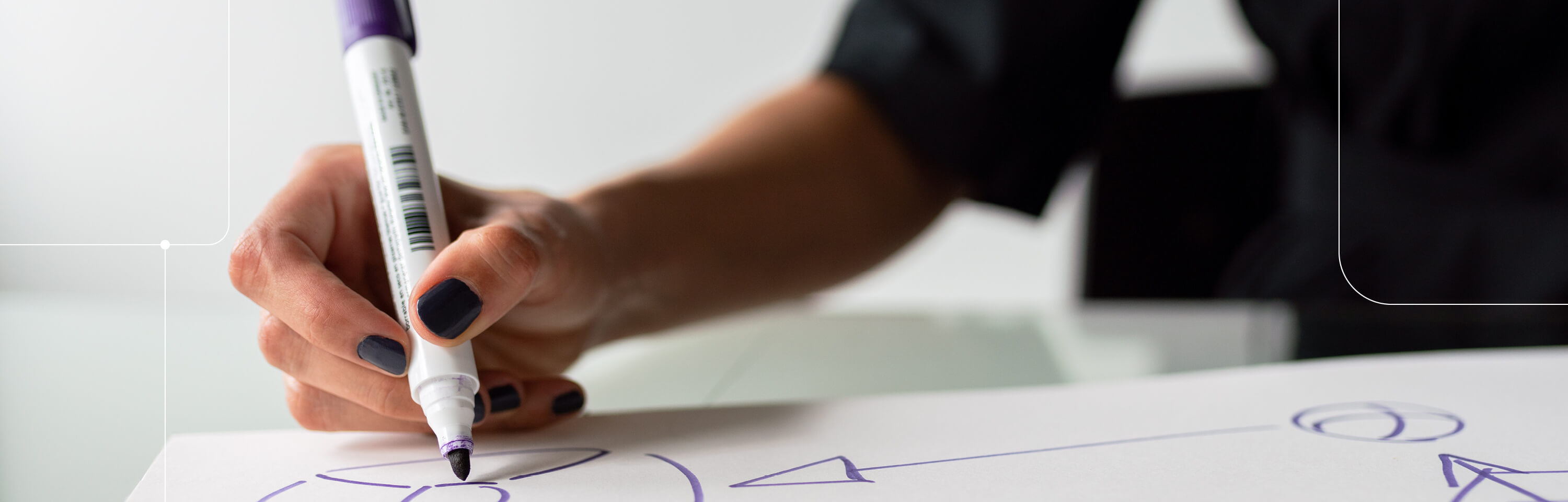 Close up of a woman's hand holding a marker, drawing a diagram