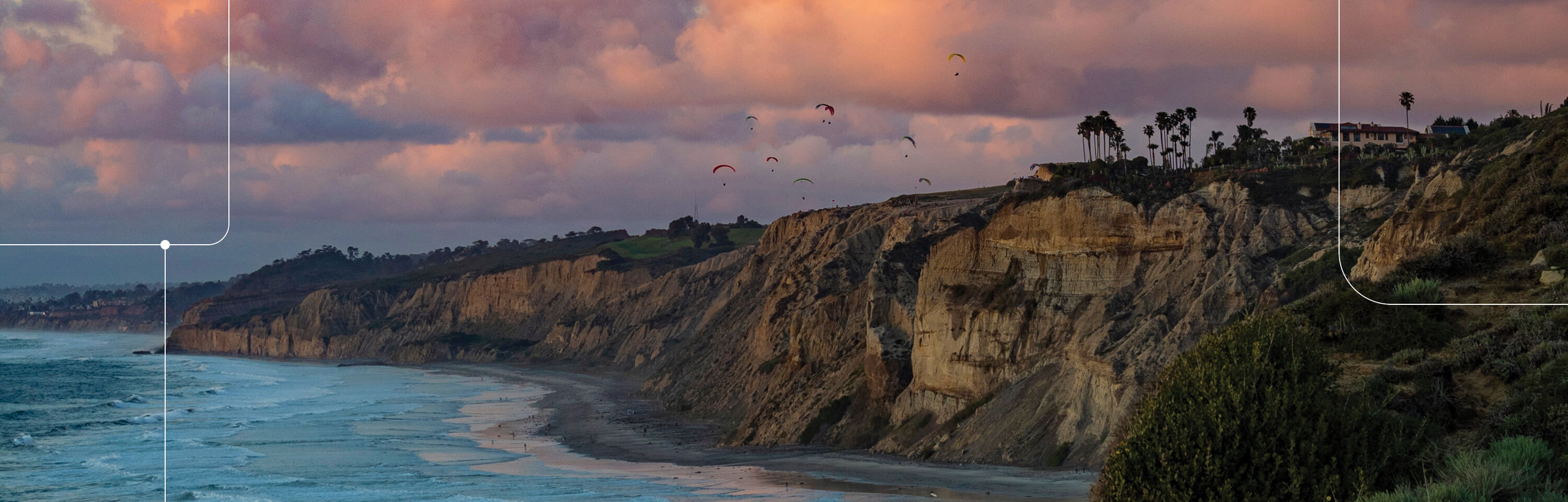 La Jolla cliffs near Black's Beach at dusk with hang gliders in flight