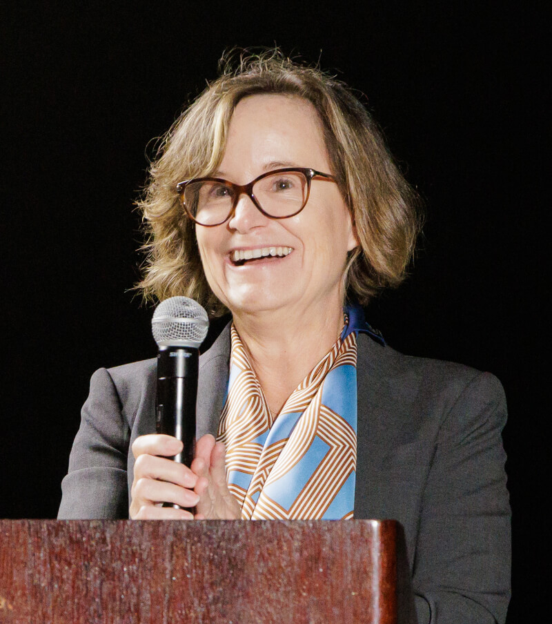 Caroline Dean Freund speaking at a podium