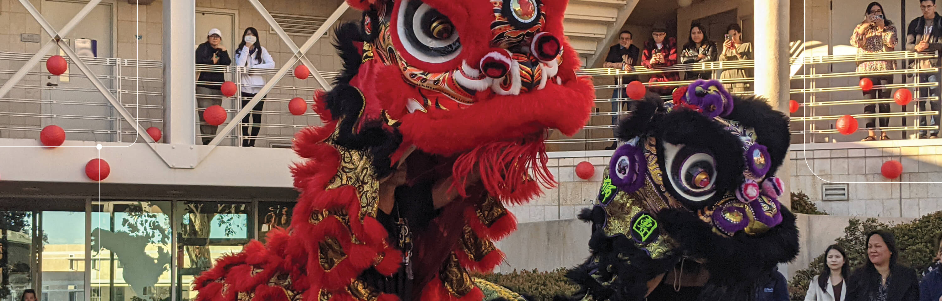 Lunar New Year lions dancing in a campus courtyard, with spectators